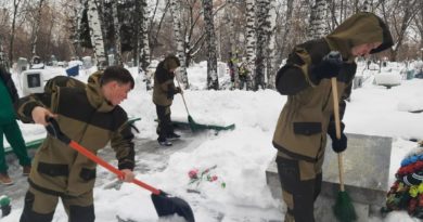 Поисковики убирают снег возле братской могилы на городском кладбище