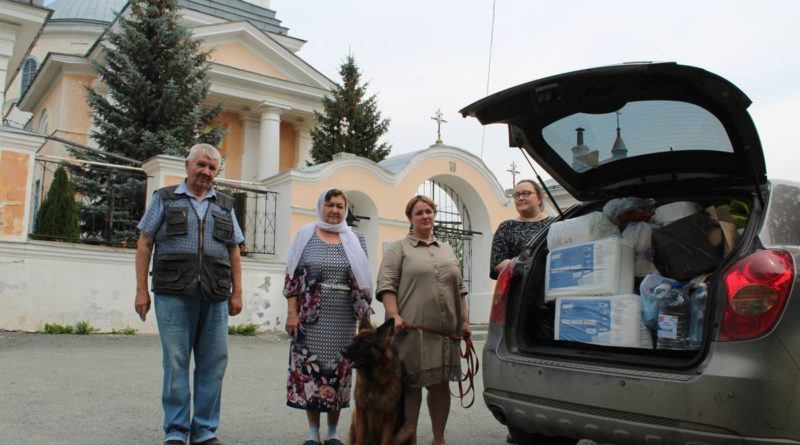 Активисты Никольского прихода Л. Леонтьев и Н. Кузнецова с волонтерами у автомобиля с гуманитарным грузом