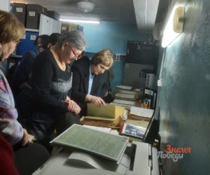 Начальник архивного отделаИрина Коновалова показывает
документы из фондов
